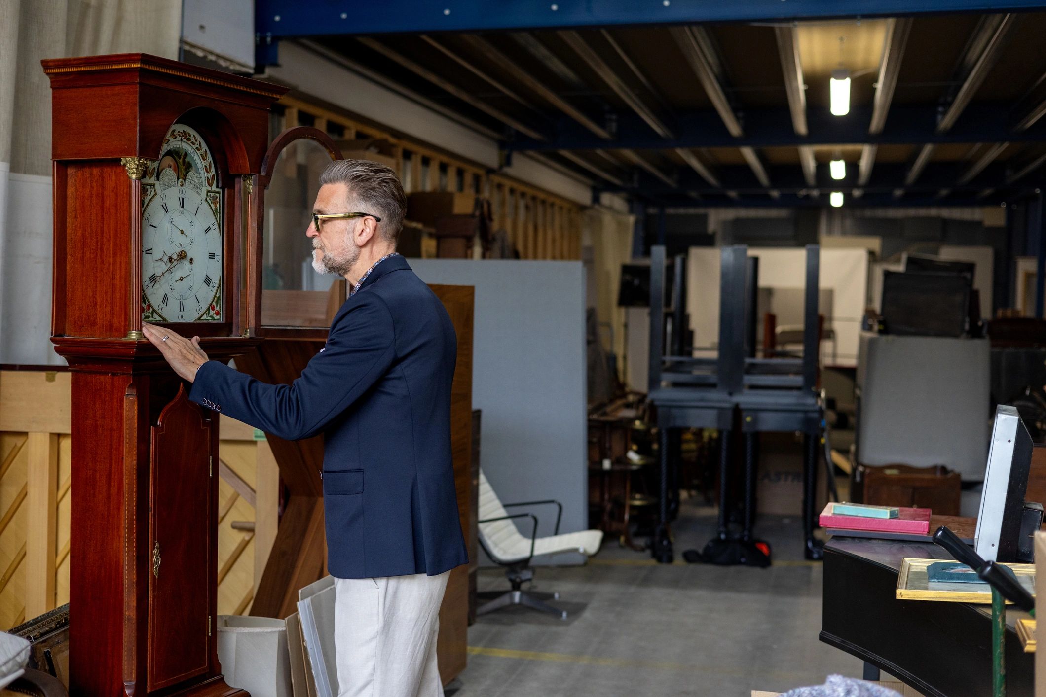 Antique clock specialist inspecting a grandfather clock